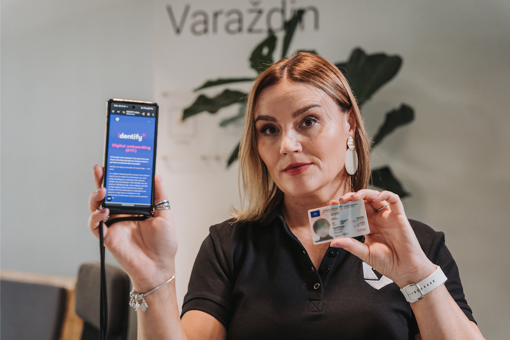 woman holding an ID card and a phone